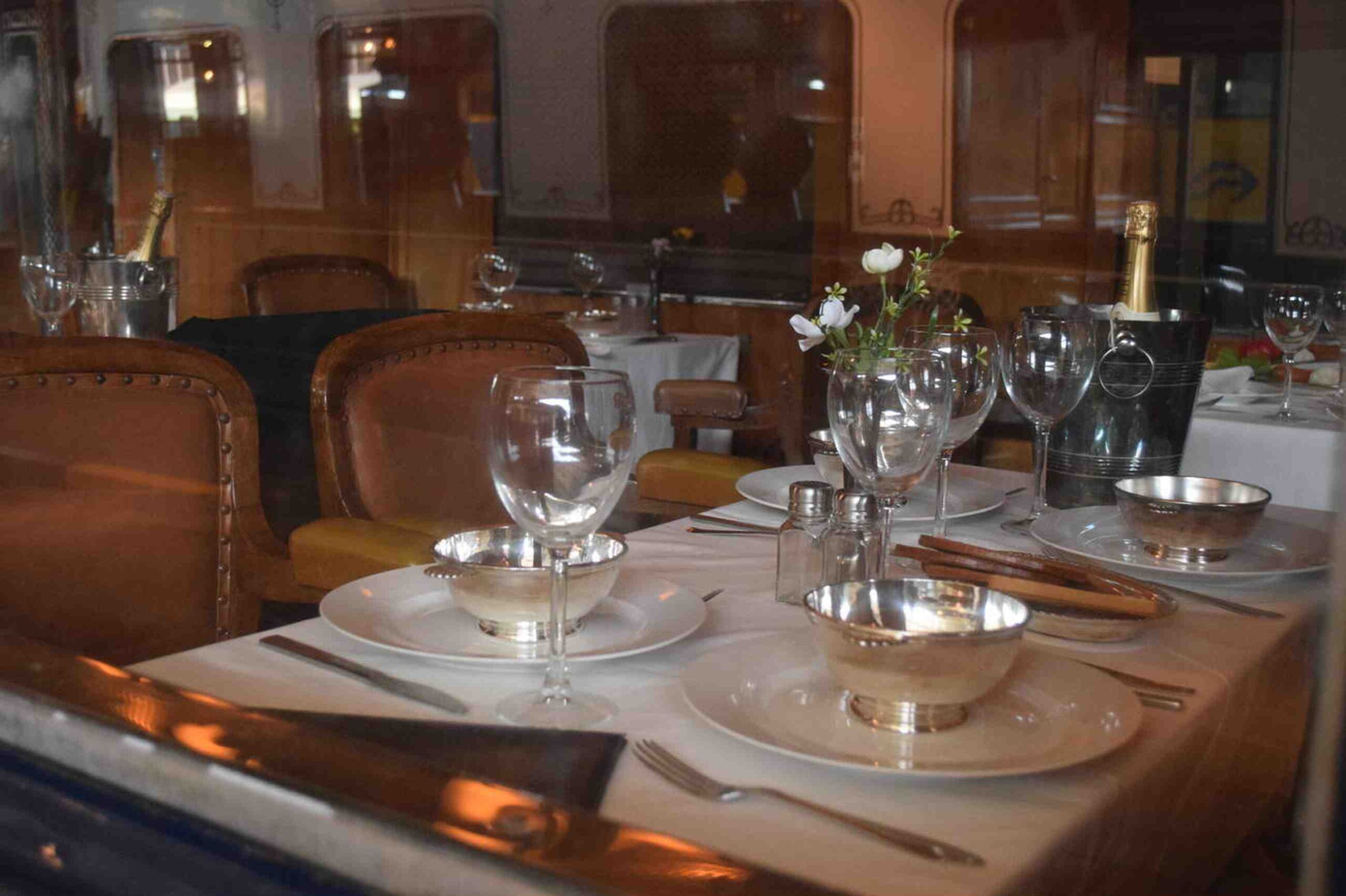 Elegant dining setup aboard The Ghan train, featuring gourmet meals, fine glassware, and a luxurious ambiance.