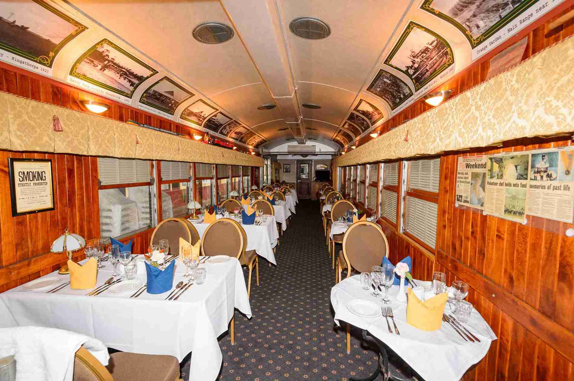 Spacious dining car with elegant table setup aboard a luxury train. | Elite Rail Journey