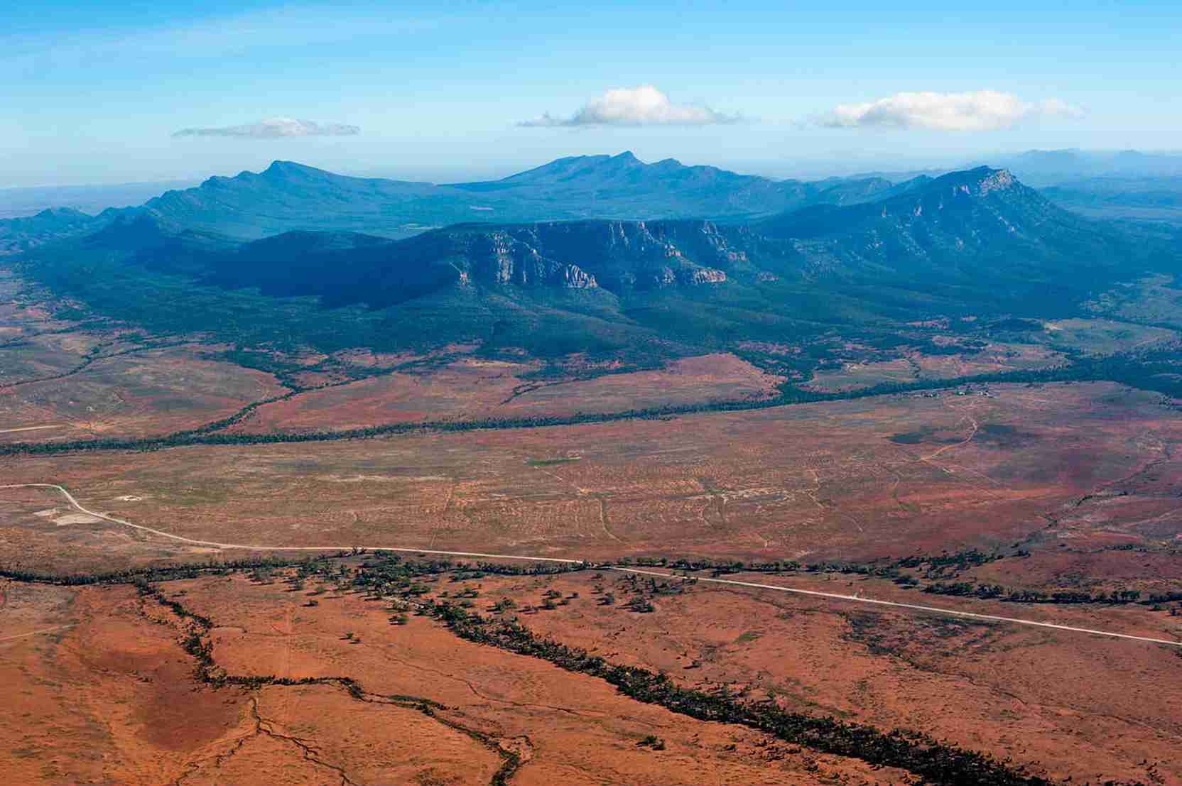 Panoramic view of the Australian outback with mountain ranges and open plains | Elite Rail Journey