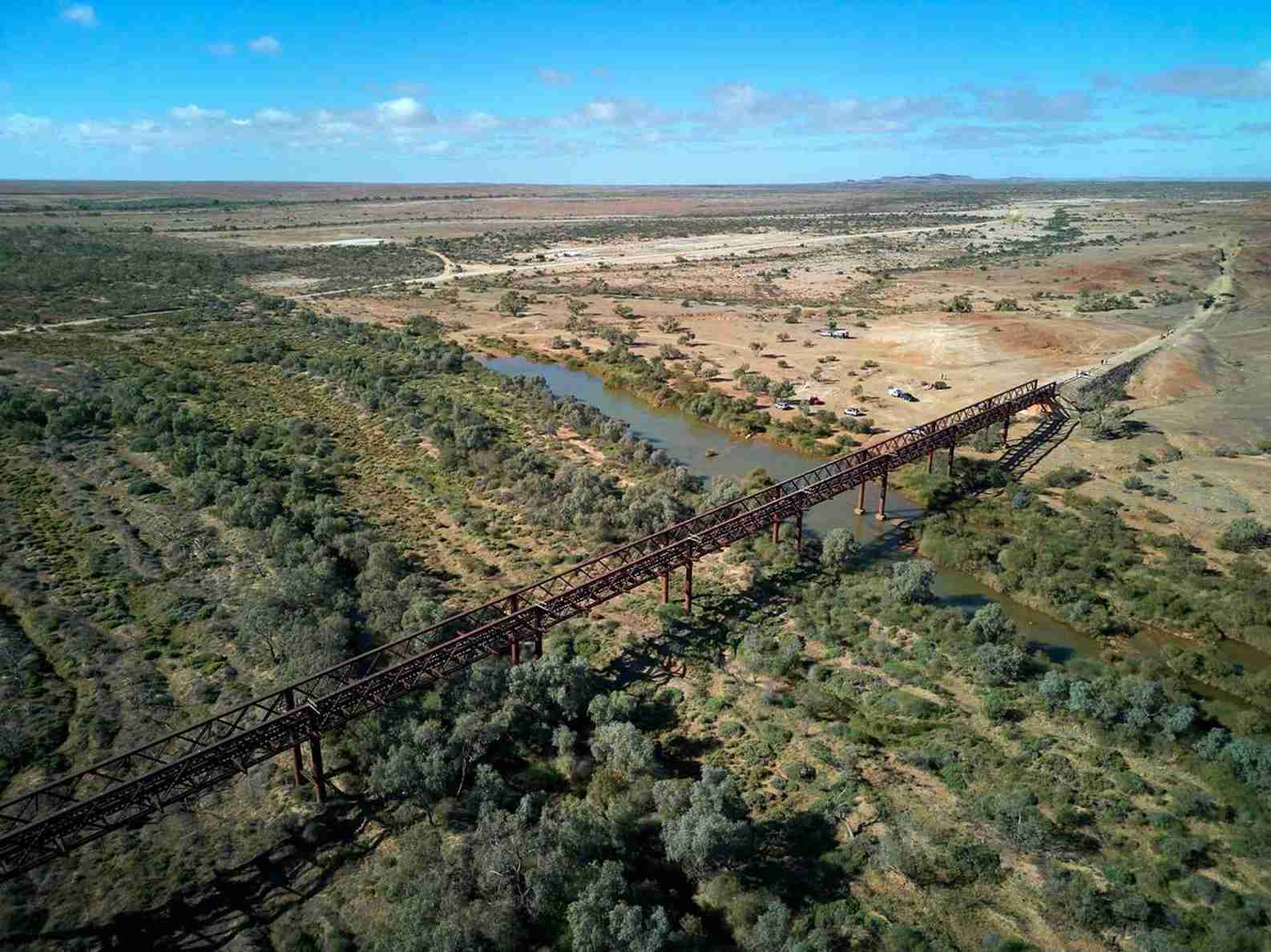 Historic railway bridge over scenic Australian outback landscape. | Elite Rail Journey